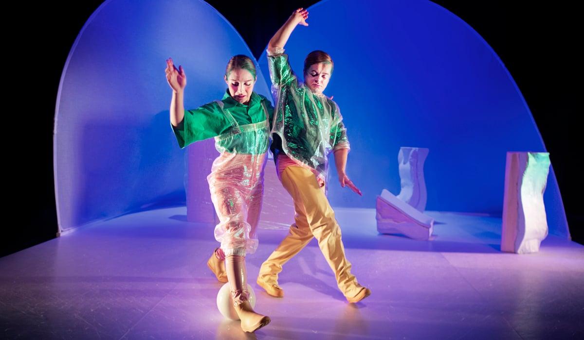 Bild på två personer som dansar i en futuristisk miljö 